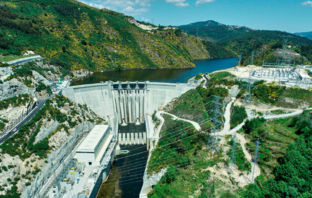 w Energy Storage System for Tâmega River The Tâmega River flows from its source in Spain, through to Portugal where it discharges into the Atlantic Ocean. Along the way it passes through ancient settlements, but also through deep narrows between mountains ideal for dams. A new energy storage system is commissioning in the Portuguese mountains, with capacity equivalent to a mega battery. The New Tâmega Energy Storage System The Portuguese government approved a new energy storage system comprising three new hydroelectric schemes along the Tâmega River in 2014. The first of these, namely the Alto Tâmega concrete double curvature arch dam, has begun generating electricity. Wikipedia confirms the following statistics: The electrical heart of the pioneering Alto Tâmega dam, comprises two 80 megawatt turbine generating units. Their maximum flow rate is 200 cubic meters-a-second, producing 139-gigawatt-hours of electricity a year. Two lateral spillways with total discharge capacity of 1,825 cubic-meters-a-second, prevent the dam over-flowing. More Information About Alto Tâmega Dam The Financial Times published more information ‘on the ground, after contributor Barney Jopson investigated the site. He describes the sound of the 230-ton water pump as a ‘roaring hum’, as it sends water four miles up the mountain to a ‘water battery, where the energy stores. The new energy storage system at Tâmega high up in the Portuguese mountains takes surplus energy from the grid. And then uses this resource to lift the water to a smaller dam higher. And then, when the grid is hungry during peak, it release the energy to the pumps-become generators, so it becomes electricity again. This energy is enough to charge 400,000 electric vehicle batteries, or sustain 2.4 million homes for a full day according to Financial Times.